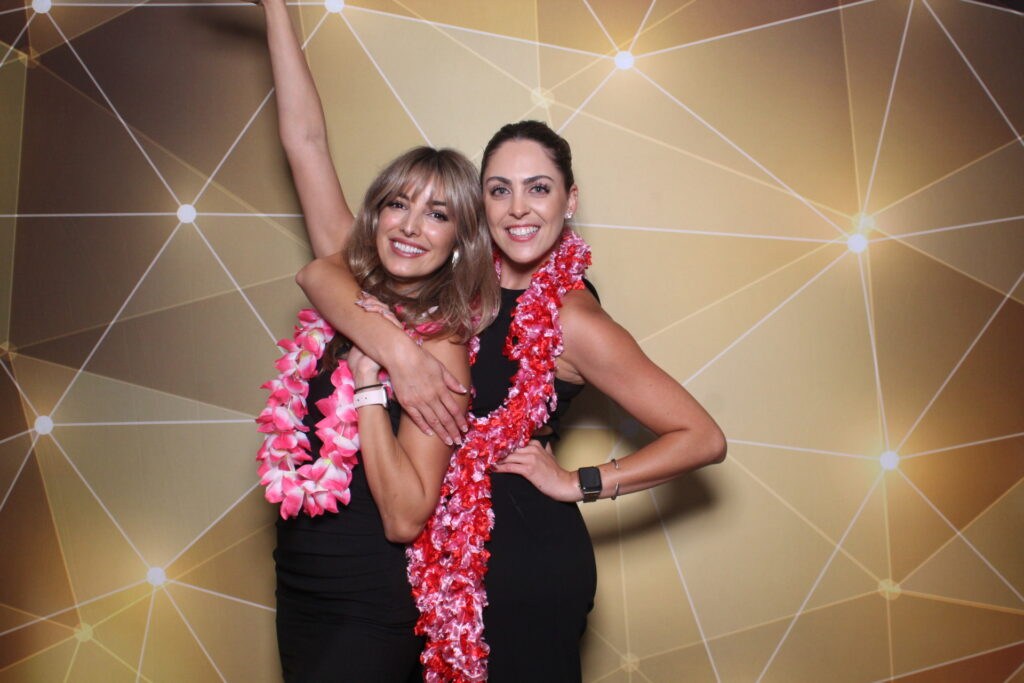 At Gala 2023 two women smile for a photo in front of a shimmering gold backdrop in California